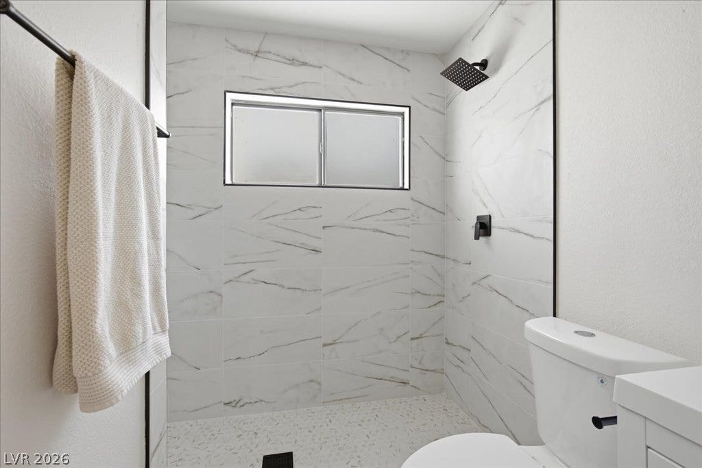 3912 Casa Grande Avenue, Las Vegas, NV 89102 Fine marble-patterned tile surrounds a modern walk-in shower beneath a frosted privacy window.