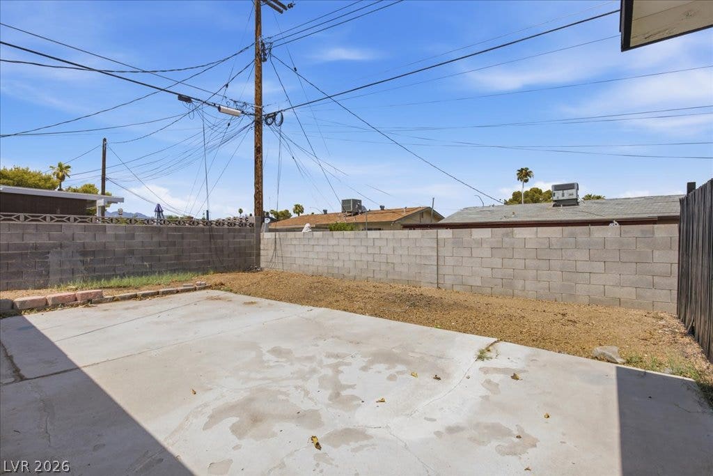 3912 Casa Grande Avenue, Las Vegas, NV 89102 A spacious backyard patio area is enclosed by privacy block fencing under open blue skies.