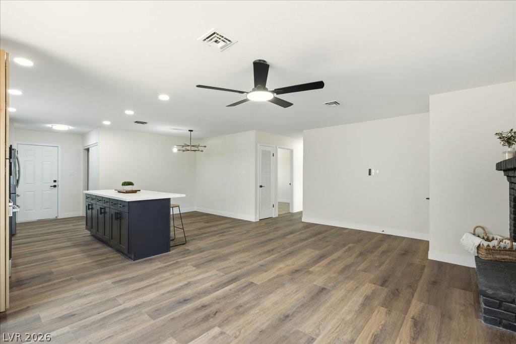 3912 Casa Grande Avenue, Las Vegas, NV 89102 Warm wood-look flooring stretches across an open living area connected to a modern kitchen.