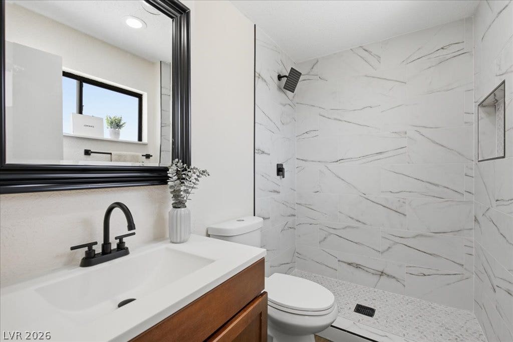 3912 Casa Grande Avenue, Las Vegas, NV 89102 Elegant stone surfaces and modern fixtures highlight this beautifully updated walk-in shower area.