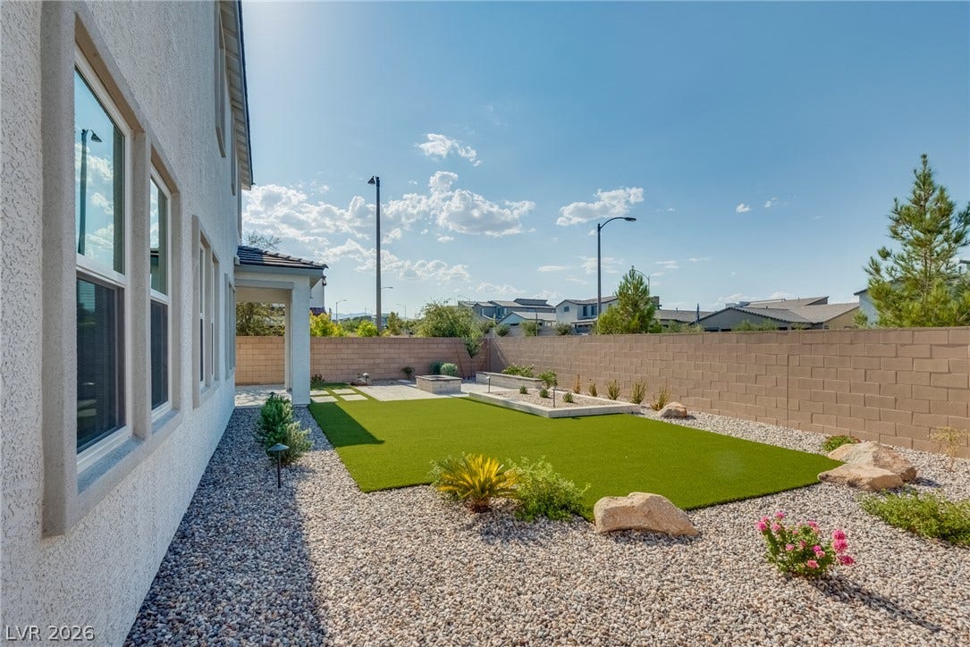 10226 Pleasant Knoll Avenue, Las Vegas, NV 89166 Low maintenance landscaping and a block privacy wall frame this neat back yard space.