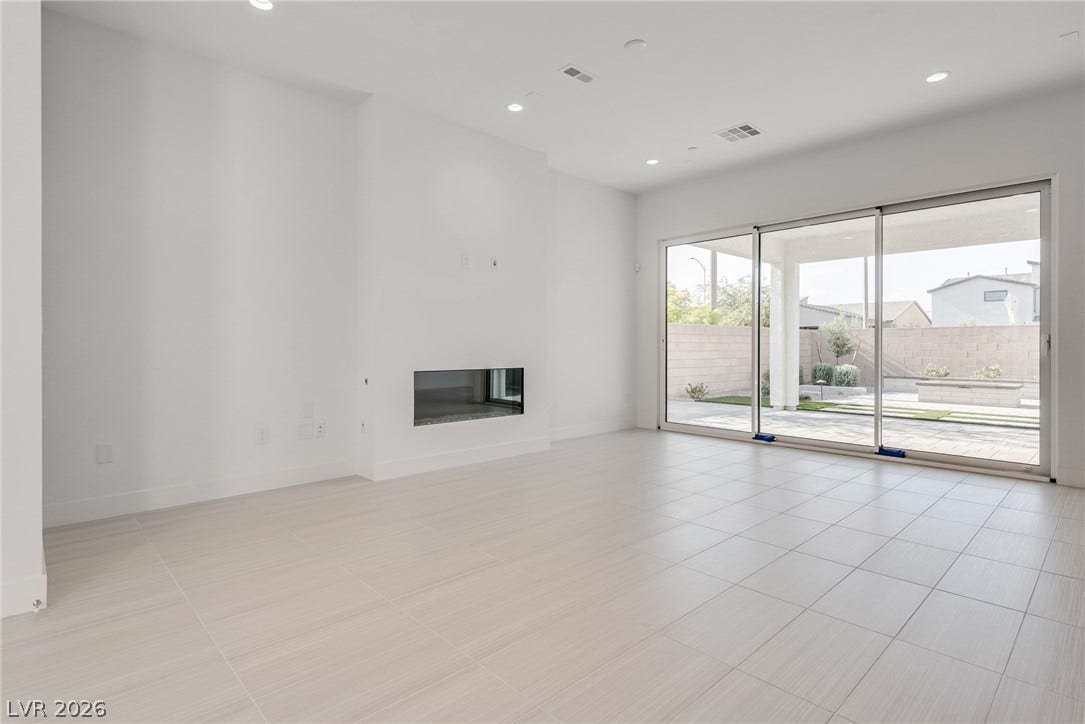 10226 Pleasant Knoll Avenue, Las Vegas, NV 89166 Beautiful tile flooring and a sleek fireplace anchor this airy modern living space.