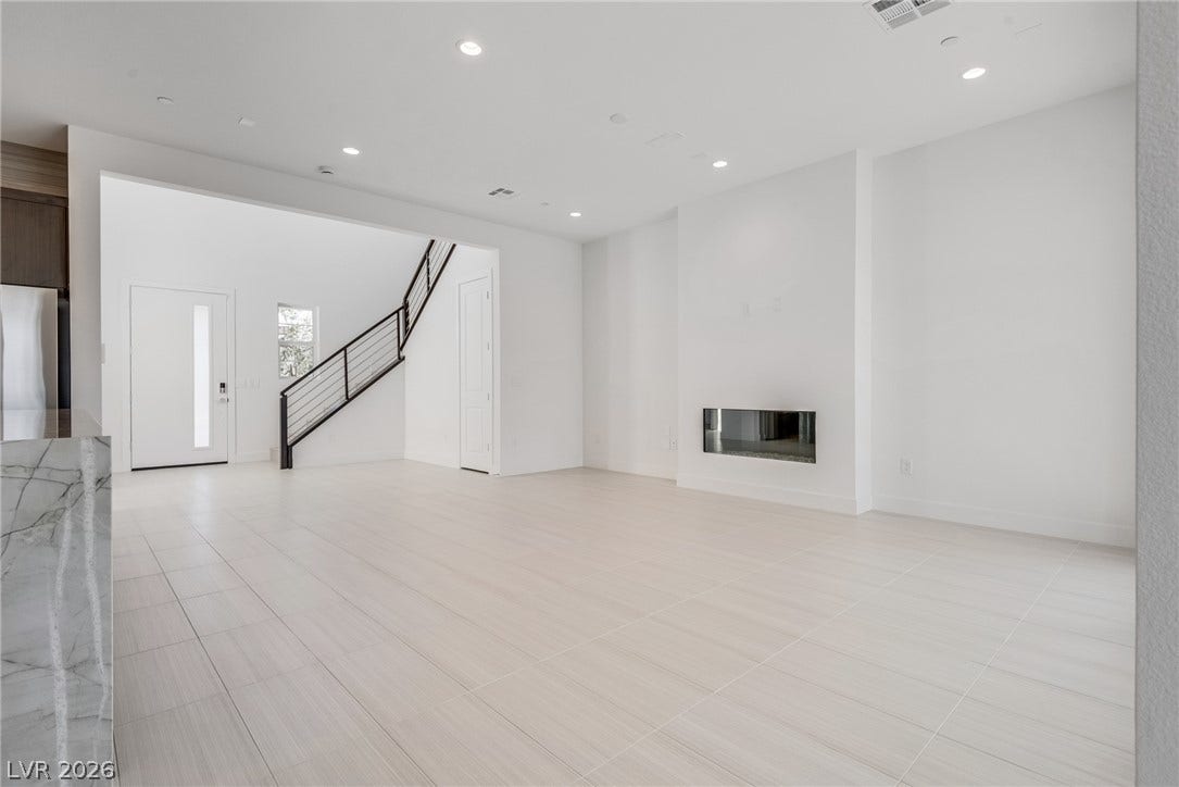 10226 Pleasant Knoll Avenue, Las Vegas, NV 89166 Clean lines and a modern fireplace define this light-filled, open living space.