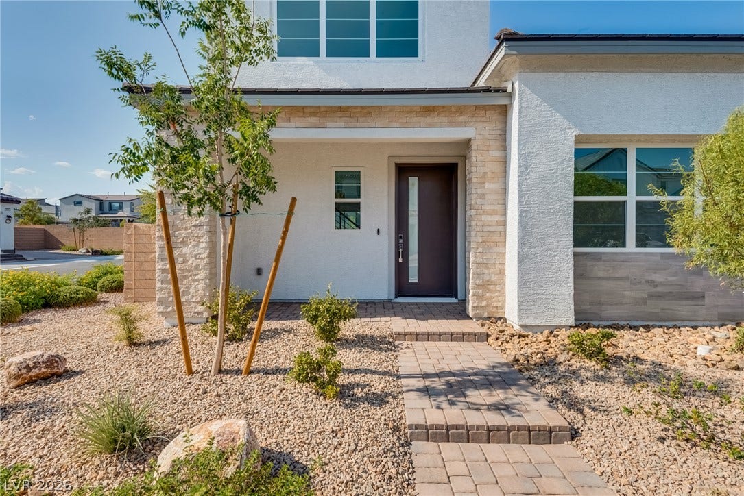 10226 Pleasant Knoll Avenue, Las Vegas, NV 89166 A stone-accented entryway features a paved walkway and desert landscaping.