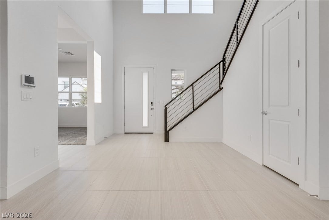 10226 Pleasant Knoll Avenue, Las Vegas, NV 89166 A soaring ceiling and sleek modern staircase define this welcoming entry foyer.
