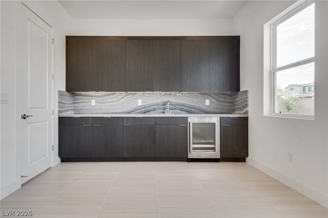 10226 Pleasant Knoll Avenue, Las Vegas, NV 89166 Downstairs flex room with upgraded cabinetry, stylish quartz countertops & backsplash. Sink & wine fridge is also included.