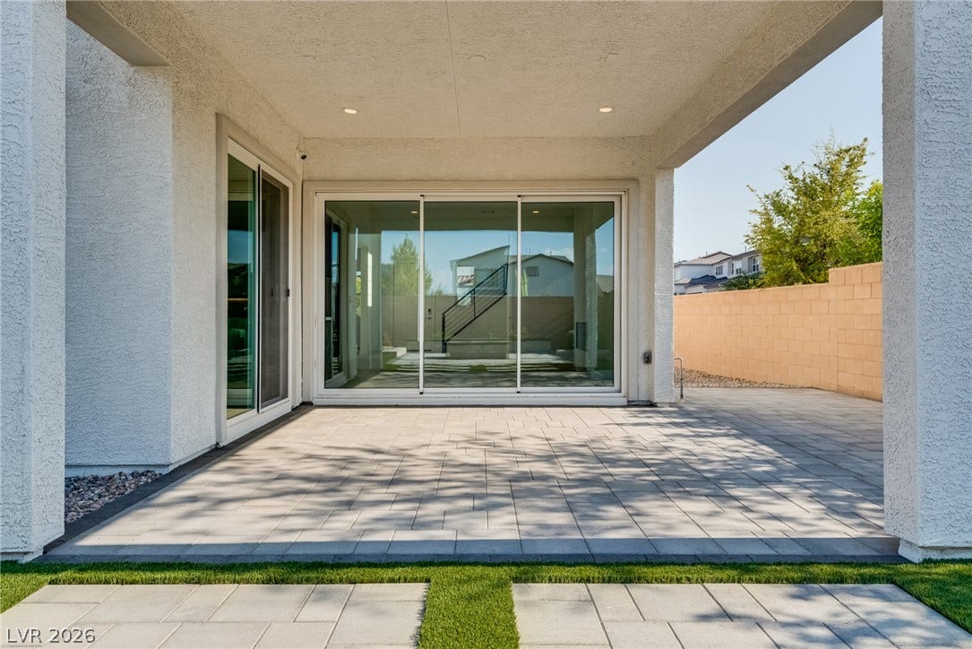 10226 Pleasant Knoll Avenue, Las Vegas, NV 89166 A spacious covered patio features clean modern lines and paving stones under a stucco overhang.