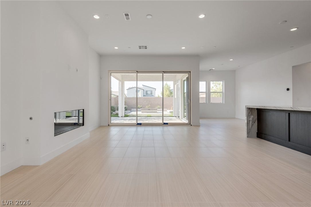 10226 Pleasant Knoll Avenue, Las Vegas, NV 89166 Clean lines and a modern fireplace anchor this open-concept great room.