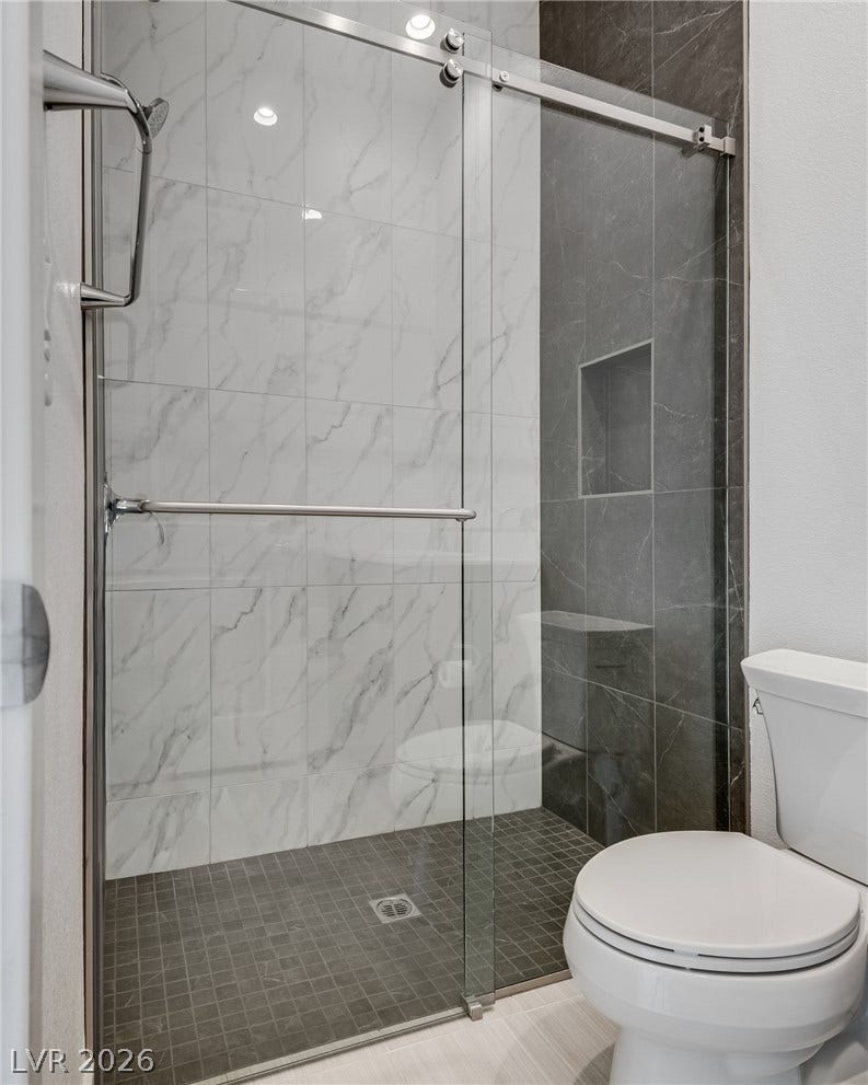 10226 Pleasant Knoll Avenue, Las Vegas, NV 89166 Modern sliding glass doors reveal a beautifully tiled walk-in shower with contrasting finishes.