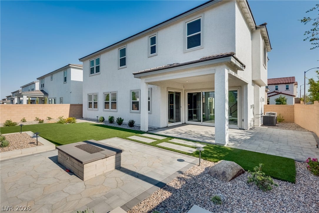 10226 Pleasant Knoll Avenue, Las Vegas, NV 89166 A spacious covered patio overlooks the manicured lawn and stone-paved fire pit area.