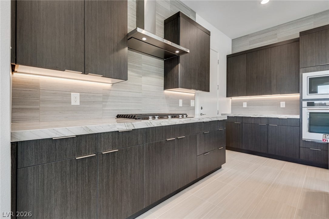 10226 Pleasant Knoll Avenue, Las Vegas, NV 89166 Streamlined cabinetry and sleek quartz countertops define this modern kitchen space.