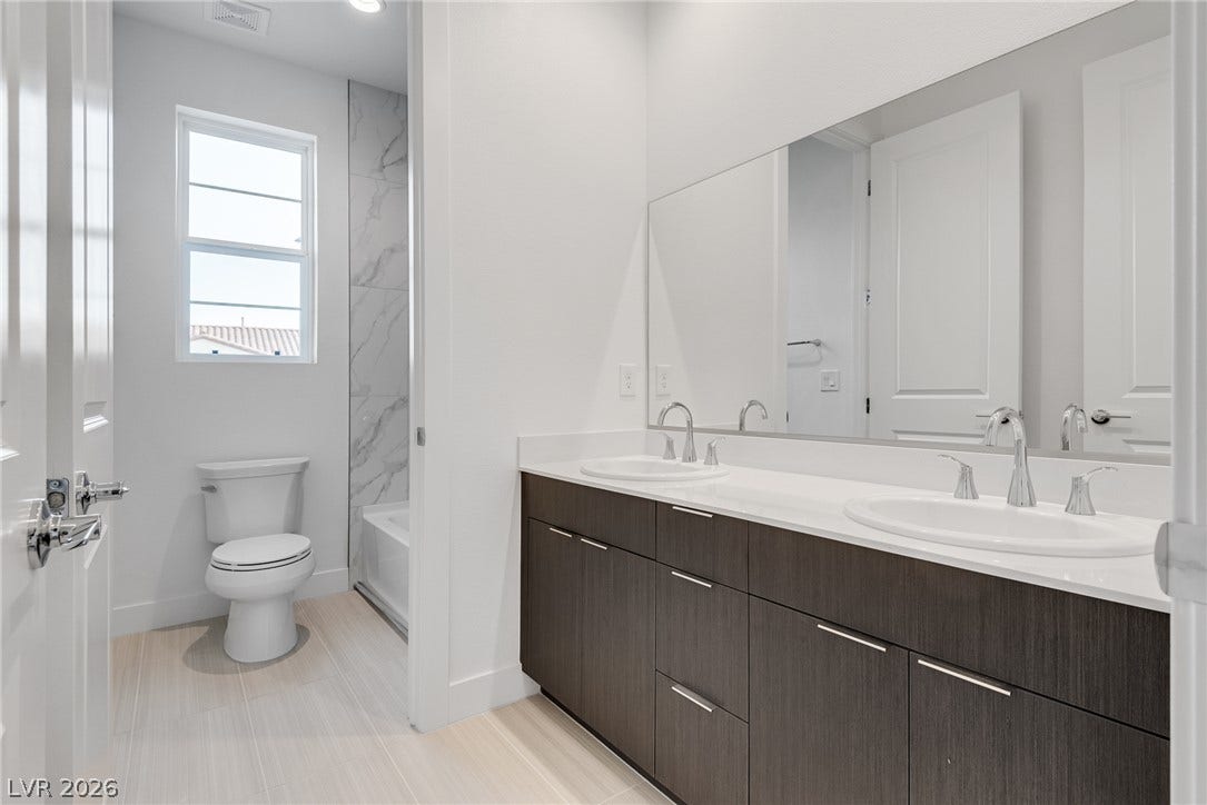 10226 Pleasant Knoll Avenue, Las Vegas, NV 89166 Clean lines and a spacious dual vanity define this modern upstairs hall bath.
