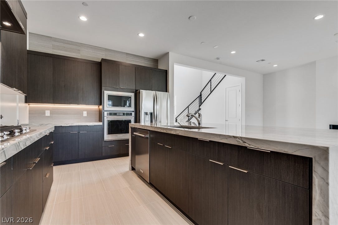 10226 Pleasant Knoll Avenue, Las Vegas, NV 89166 Elegant dark cabinetry and quartz countertops anchor this modern culinary space.