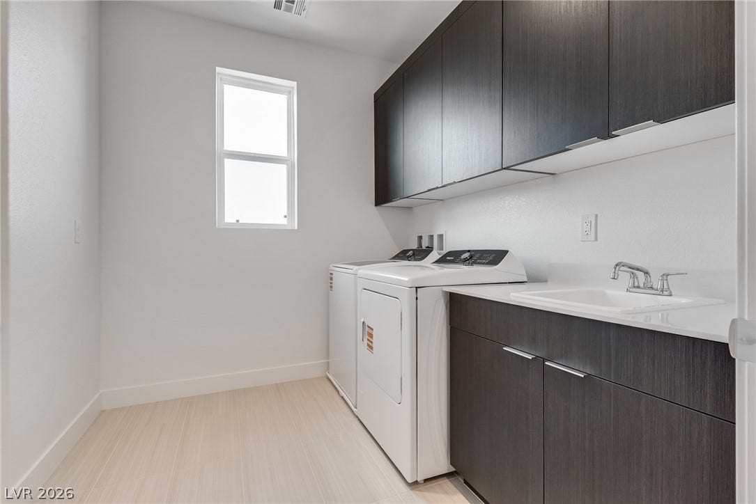 10226 Pleasant Knoll Avenue, Las Vegas, NV 89166 Dark modern cabinetry and a deep utility sink elevate this highly functional workspace.