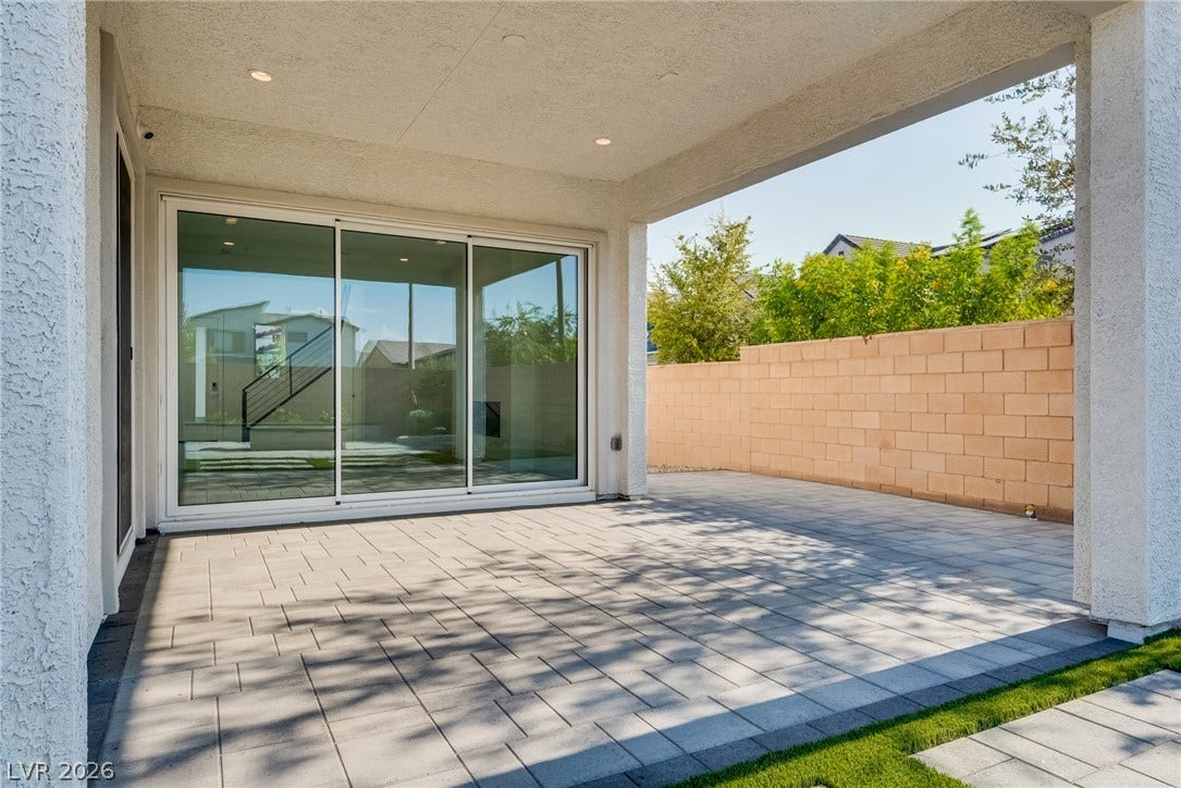 10226 Pleasant Knoll Avenue, Las Vegas, NV 89166 A covered brick paver patio extends seamlessly from the home through sliding glass doors.