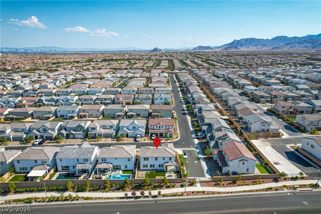 10226 Pleasant Knoll Avenue, Las Vegas, NV 89166 Aerial view showcases the master-planned neighborhood against a dramatic mountain backdrop.