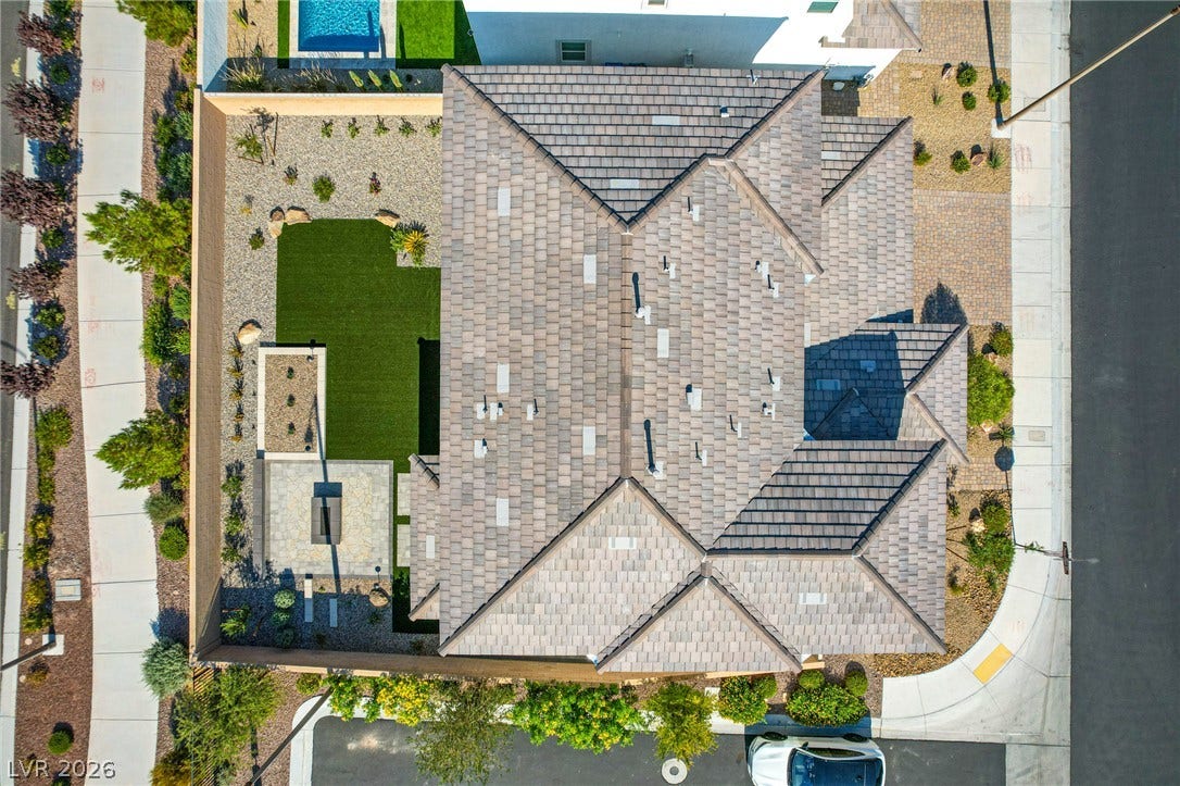 10226 Pleasant Knoll Avenue, Las Vegas, NV 89166 A top-down aerial view highlights the multi-angled tile roof and landscaped backyard design.