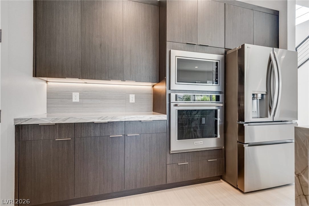 10226 Pleasant Knoll Avenue, Las Vegas, NV 89166 Sleek modern cabinetry and integrated stainless steel appliances anchor this contemporary culinary space.