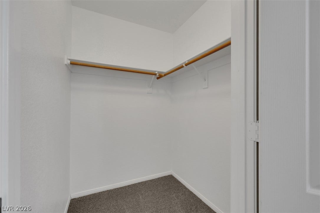 657 Anne Lane, #657, Henderson, NV 89015 Ample hanging rods and shelving maximize the organization potential in this carpeted walk-in closet.