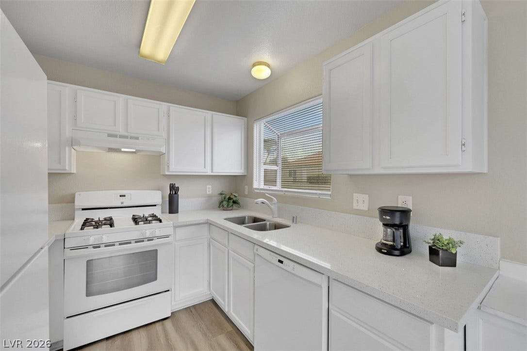 657 Anne Lane, #657, Henderson, NV 89015 Crisp white cabinetry paired with durable solid surface countertops creates an inviting workspace.