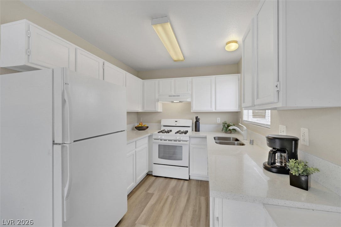 657 Anne Lane, #657, Henderson, NV 89015 Bright white cabinetry complements durable countertops and wood-look flooring in this functional culinary space.