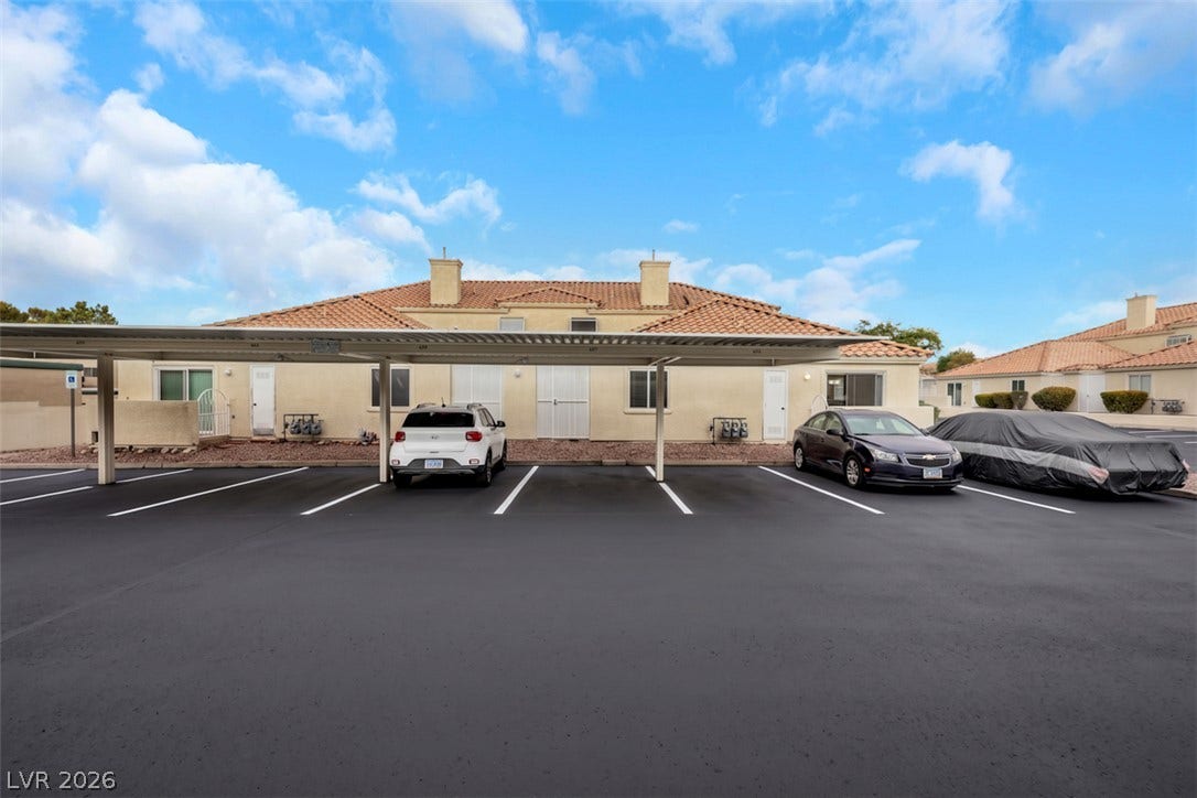 657 Anne Lane, #657, Henderson, NV 89015 Ample resident parking sits directly in front of the stucco exterior under tile roofing.