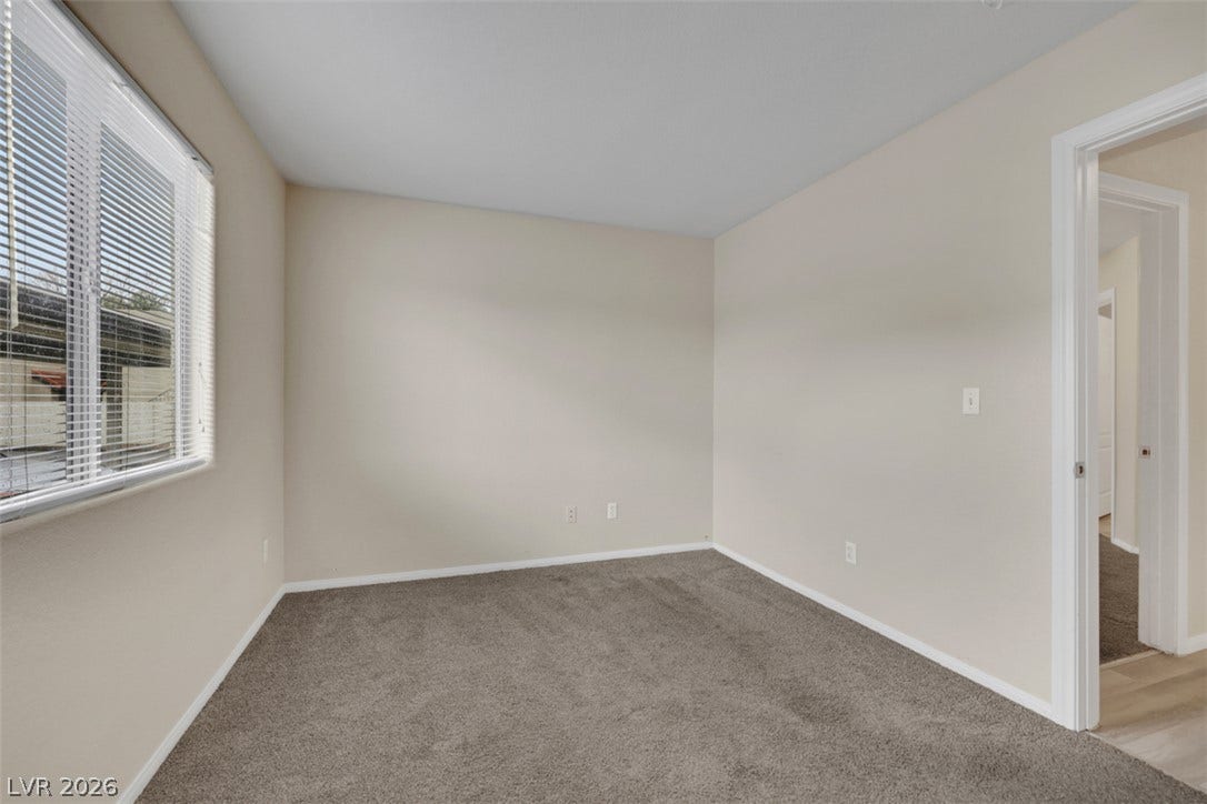 657 Anne Lane, #657, Henderson, NV 89015 A spacious bedroom featuring plush wall-to-wall carpeting and a wide window.