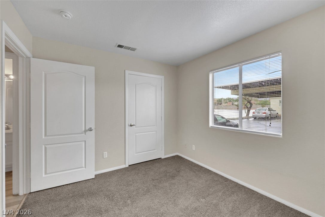 657 Anne Lane, #657, Henderson, NV 89015 Plush carpeting and a large window create a comfortable, well-lit secondary bedroom space.