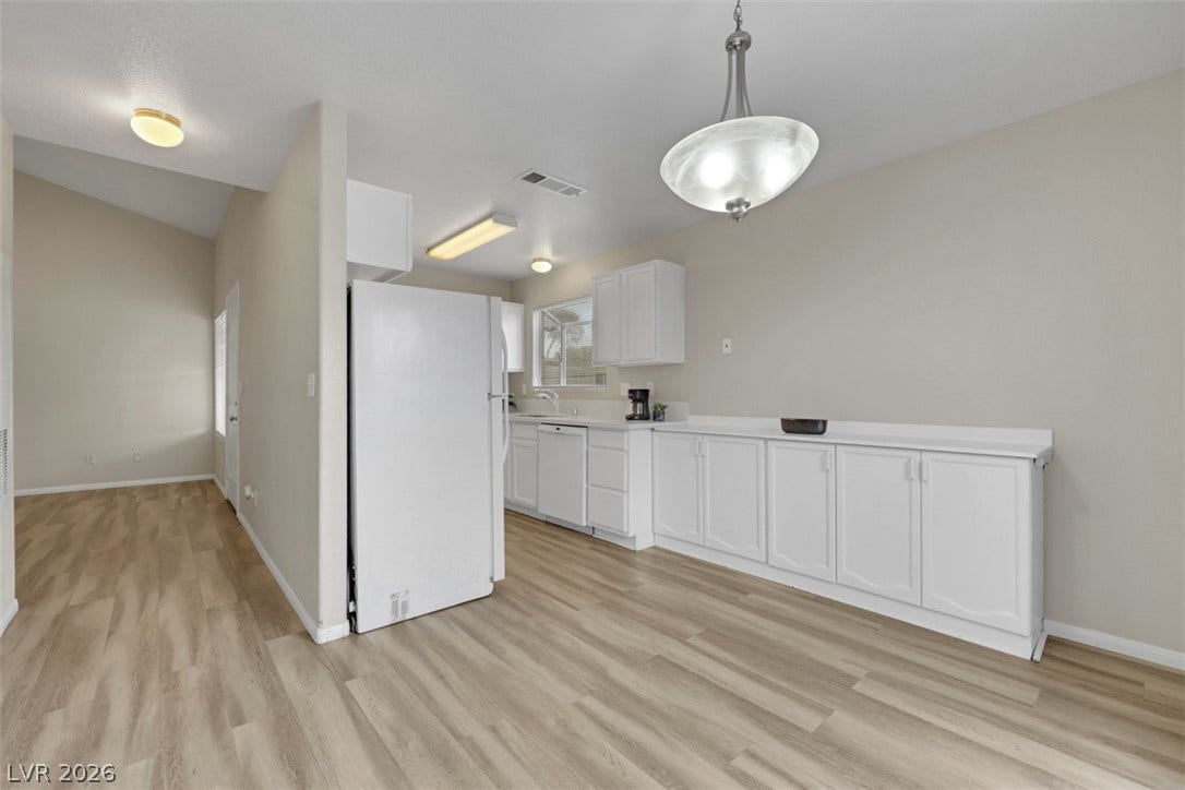 657 Anne Lane, #657, Henderson, NV 89015 Warm wood-style flooring runs throughout this functional culinary space and adjoining hallway.