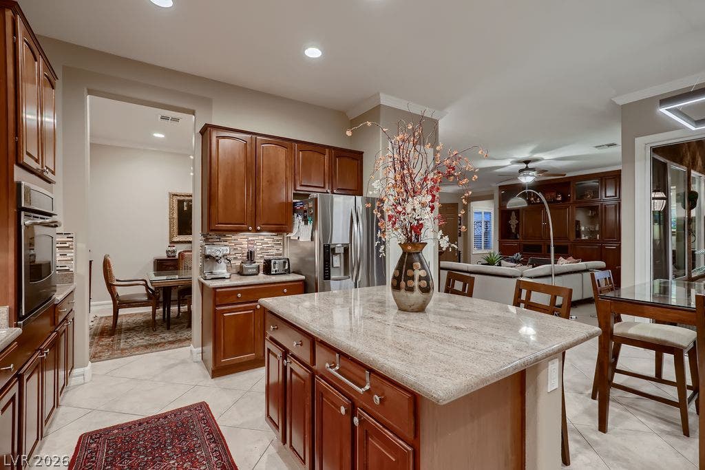 2284 Savannah River Street, Henderson, NV 89044 Rich wood cabinetry and stone countertops anchor this central kitchen overlooking the living space.