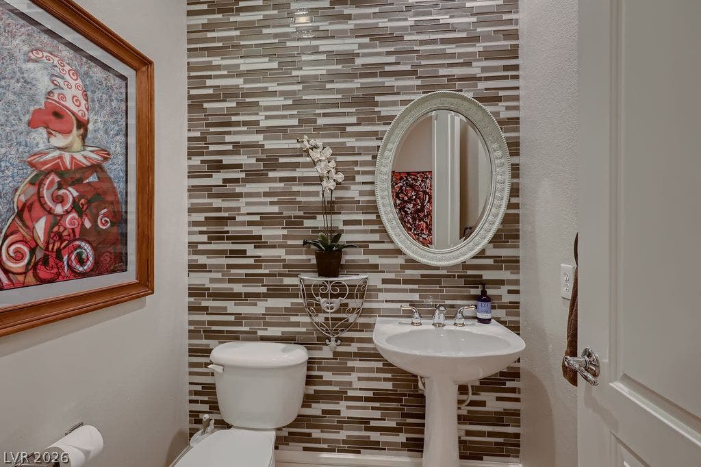 2284 Savannah River Street, Henderson, NV 89044 An accent wall of mosaic glass tile defines this powder room featuring a classic pedestal sink.