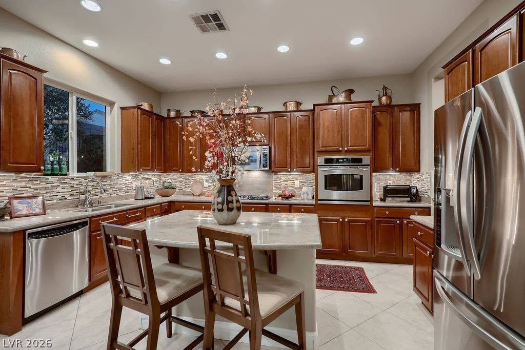 2284 Savannah River Street, Henderson, NV 89044 Gleaming stone countertops and rich wooden cabinetry anchor this central culinary space.