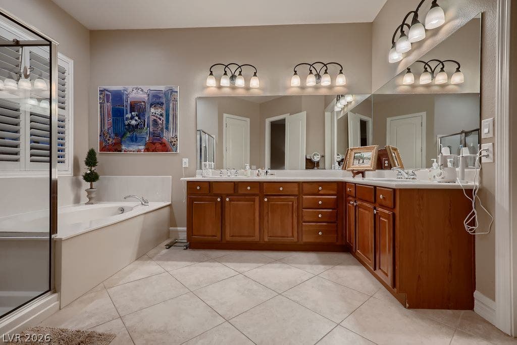 2284 Savannah River Street, Henderson, NV 89044 A spacious bathroom features an L-shaped wooden vanity, tile flooring, and a soaking tub.