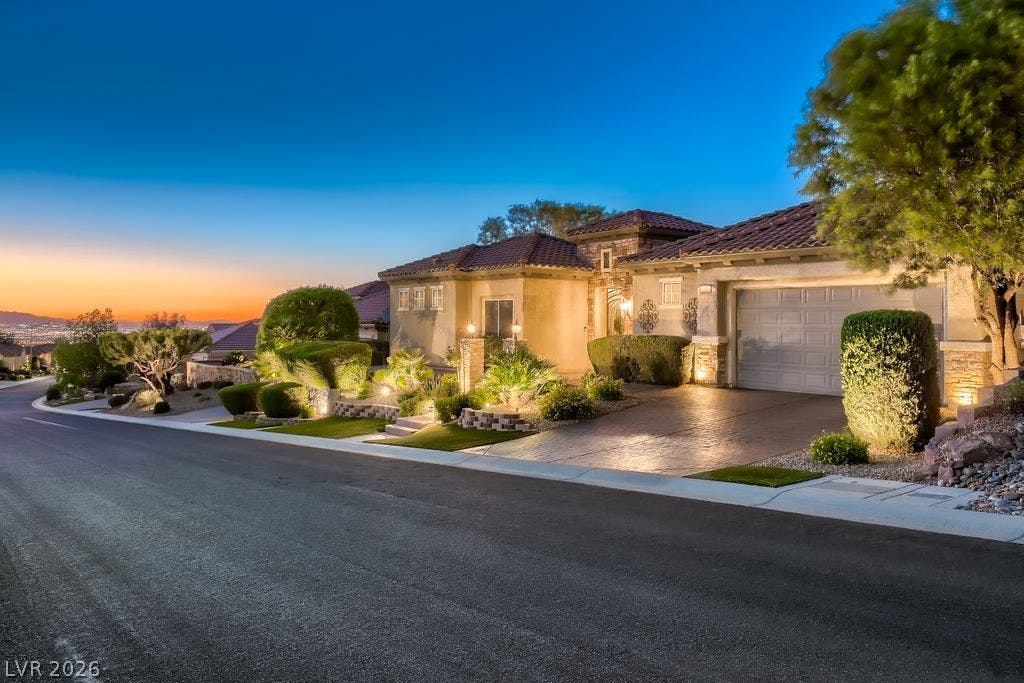 2284 Savannah River Street, Henderson, NV 89044 A quiet residential street frames the stone accented exterior under a twilight sky.