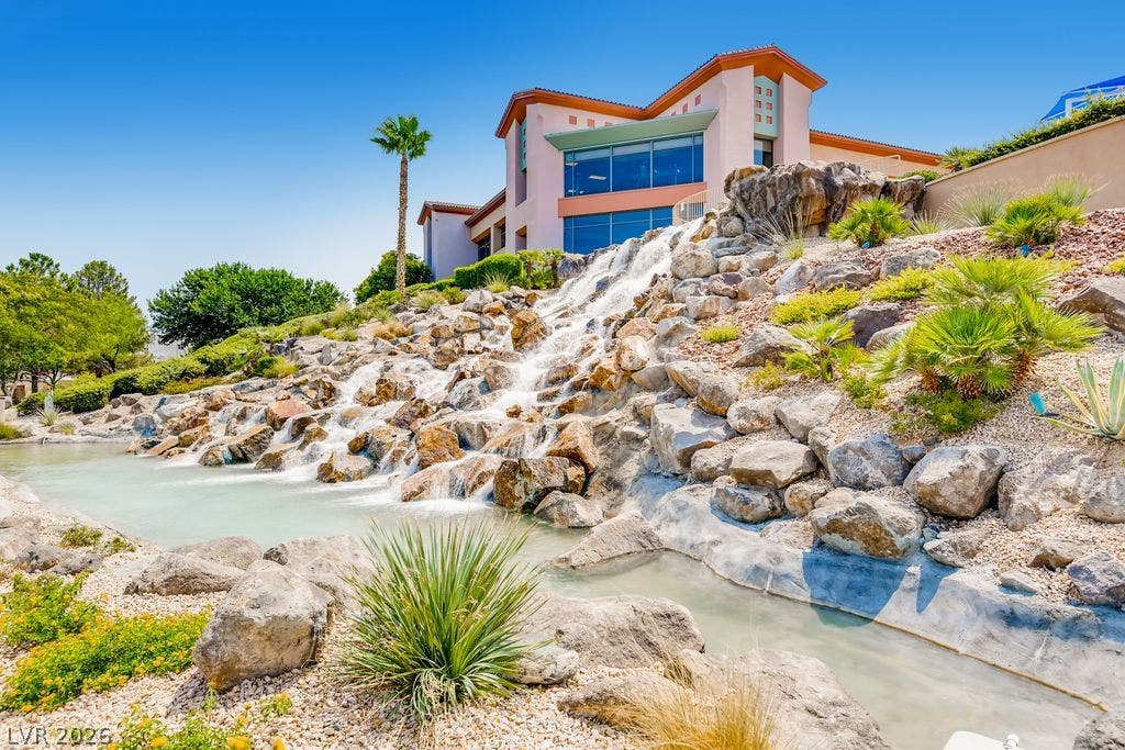 2284 Savannah River Street, Henderson, NV 89044 Dramatic rock waterfalls cascade down the landscaped hillside beneath a striking contemporary structure.