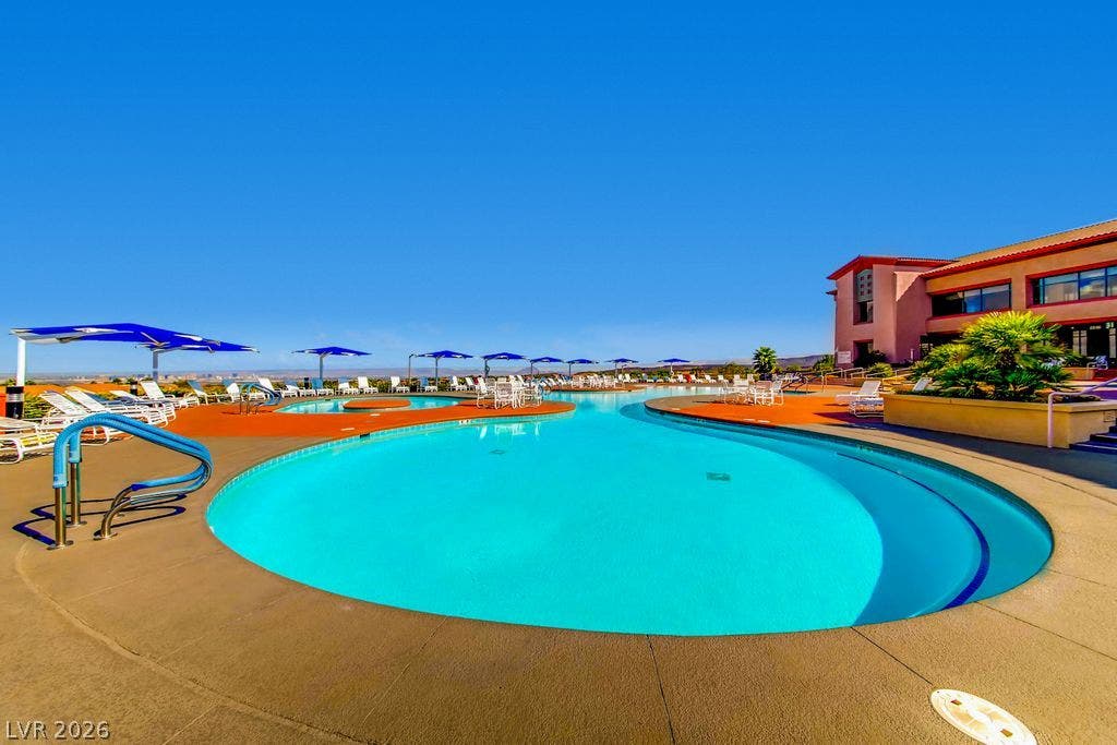 2284 Savannah River Street, Henderson, NV 89044 An expansive outdoor swimming pool sits beside the building under a clear blue sky.
