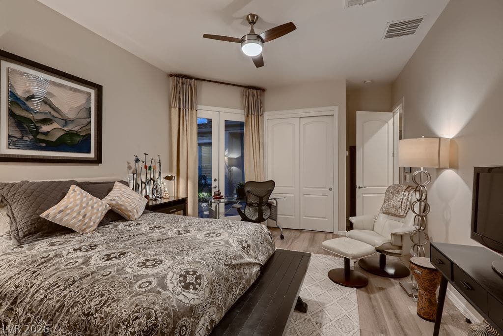2284 Savannah River Street, Henderson, NV 89044 Double doors open to the patio from this peaceful bedroom with wood-look flooring.