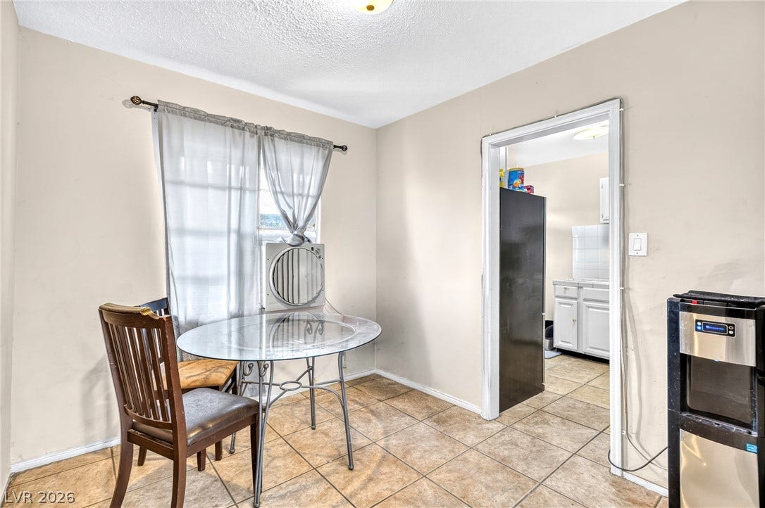 Tiled flooring and a wide doorway define this functional dining area.