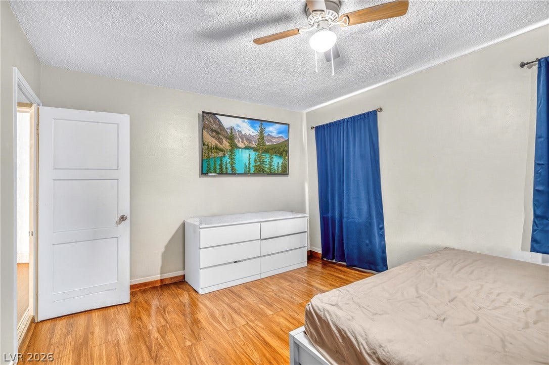 Rich hardwood flooring adds natural warmth to this comfortable bedroom space.