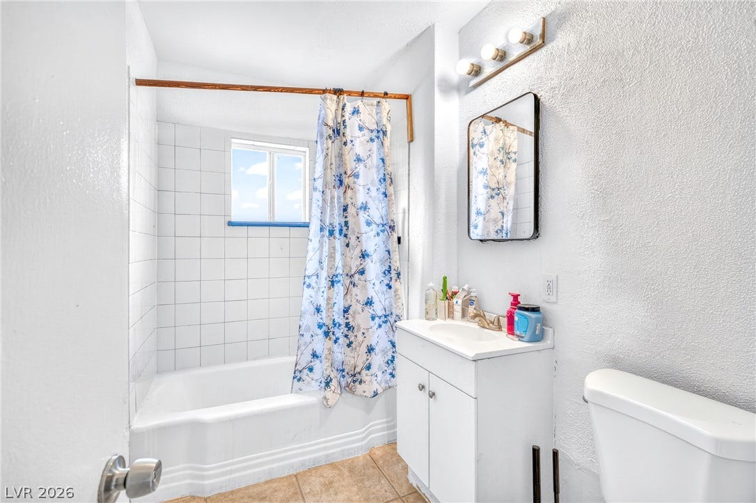 A classic bathtub and tiled shower alcove anchor this bathroom layout.