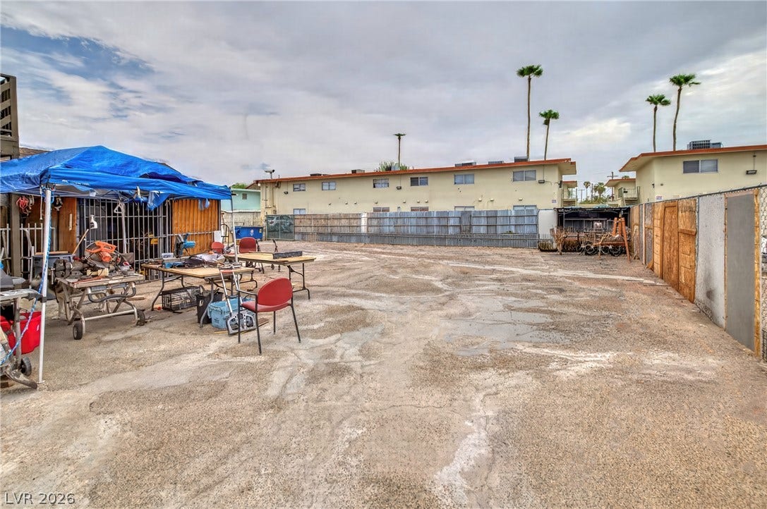 A spacious exterior lot surrounded by fencing provides ample room for storage or outdoor activities.