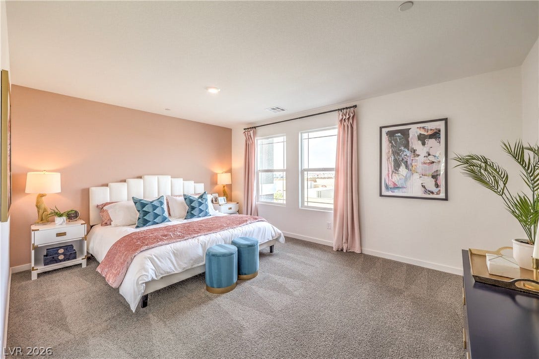 906 Pink Sugarbird Street, Henderson, NV 89011 Natural light streams through double windows across a generously sized carpeted bedroom.