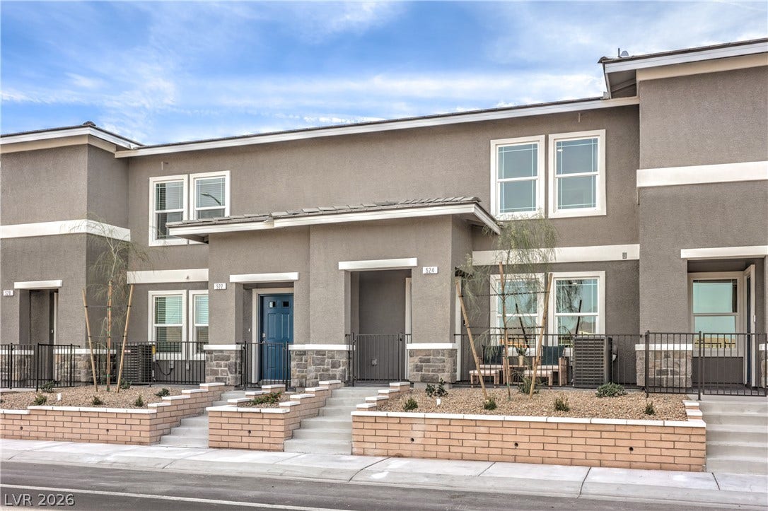 906 Pink Sugarbird Street, Henderson, NV 89011 Modern multi-level exterior architecture showcases structured masonry planters, neat stucco finishes, and a sidewalk-lined entrance.