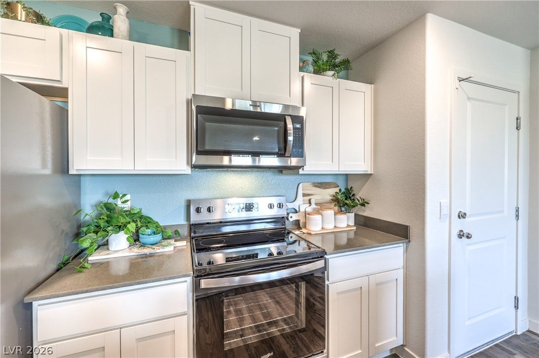 906 Pink Sugarbird Street, Henderson, NV 89011 Sleek stone countertops and classic shaker cabinetry define this functional culinary space.