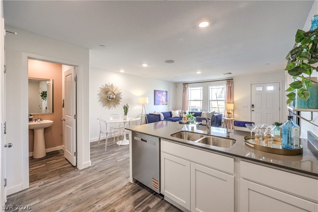 906 Pink Sugarbird Street, Henderson, NV 89011 An open-concept living area flows seamlessly past a central prep island with wood-look flooring.