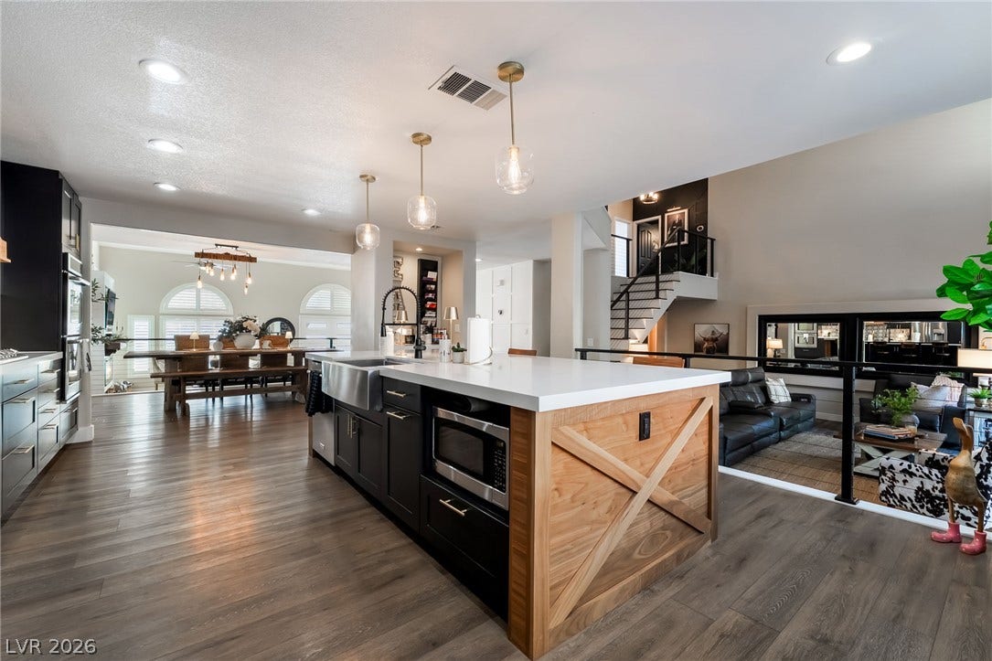 Gleaming wood-look floors anchor a modern kitchen open to the surrounding living spaces.