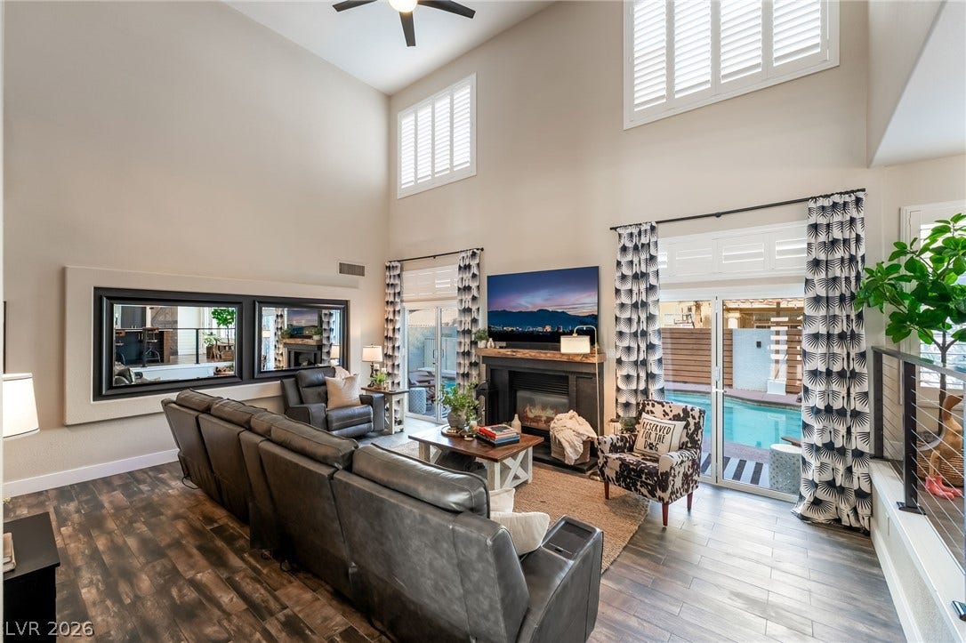 High ceilings and towering windows frame the pool view from this spacious living area.