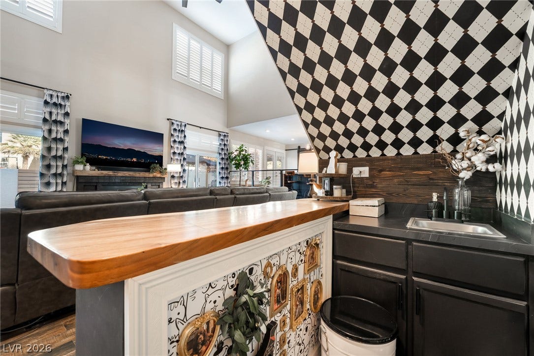 A stylish wet bar with custom woodwork integrates seamlessly into the vaulted living area.