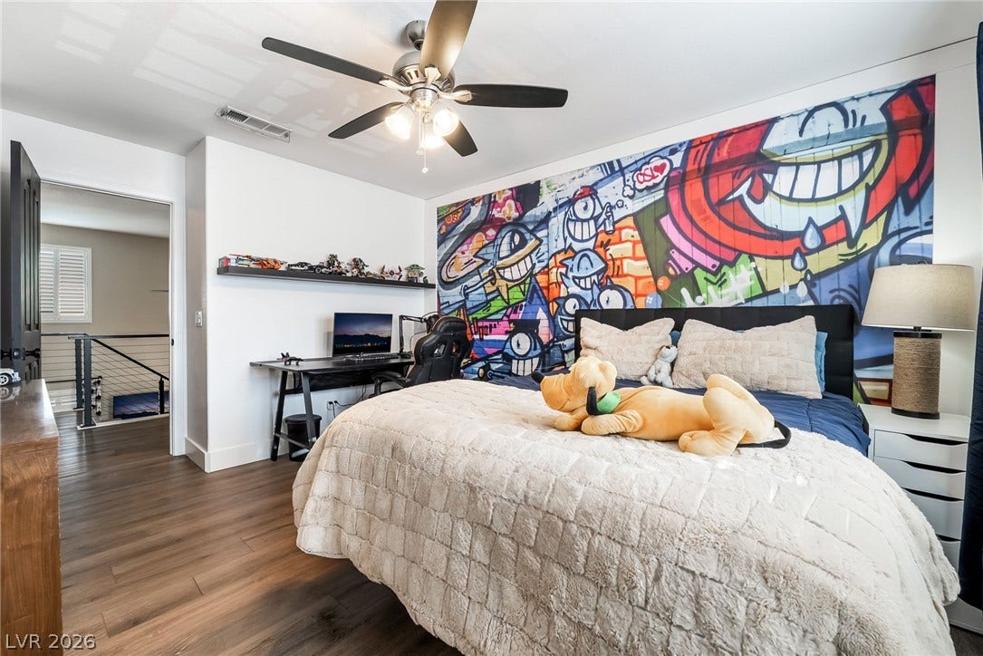 Rich wood-look flooring and clean white lines define this versatile second-floor bedroom.