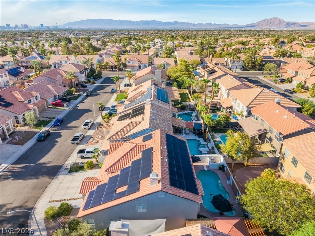 Tiled roofs equipped with solar panels look out over a quiet residential neighborhood.